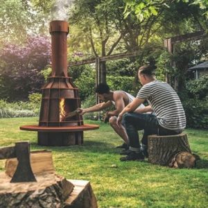 A man adding wood to a garden wood burner