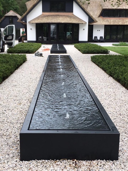 Long black water feature on a drive way