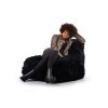 woman sitting on black fur bean bag